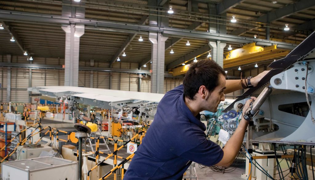Trabajador aplicando sellante en la estructura de un avión para garantizar su seguridad
