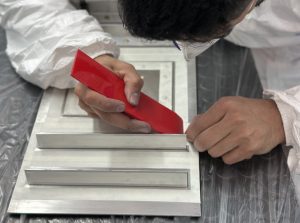Alumno poniendo cinta para proteger las zonas que no deben sellarse