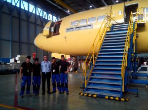Grupo de alumnos junto con el formador visitando un hangar donde se encuentra un avión en construcción