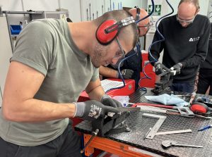 Alumno del curso Montador Aeronáutico limando una placa de metal