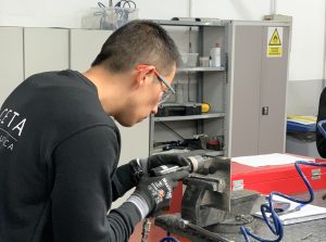 Alumno del curso Montador de Estructuras Aeronáuticas taladrando una placa de metal