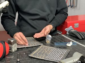 Alumno del curso Montador Aeronáutico colocando remaches en una placa de metal