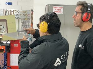 Alumno del curso Montador de Estructuras Aeronáuticas verificando la distancia entre dos parte de una placa de metal