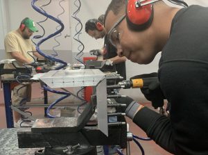 Alumno del curso Montador de Estructuras Aeronáuticas aprendiendo a taladrar una placa de metal