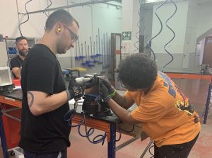 Alumnos del curso Montador de Estructuras Aeronáuticas trabajando juntos para remachar una placa de metal