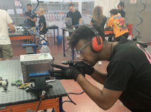Alumno del curso Montador Aeronáutico taladrando la caja de metal de su proyecto final de curso
