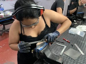 Alumna del curso Montador Aeronáutico limando una placa de metal