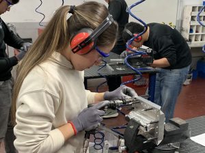 Alumna del curso Montador Aeronáutico taladrando una placa de metal para su proyecto final
