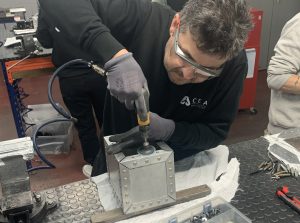 Alumno del curso Montador de Estructuras Aeronáuticas lijando una caja de metal