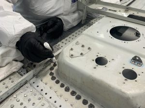 Alumna aplicando encapsulado de cabezas de uniones durante las clases prácticas del curso Sellador Aeronáutico