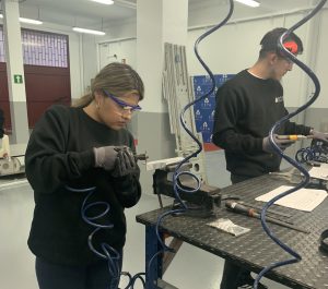 Alumna del curso Montador Aeronáutico recortando una placa de metal para su proyecto final