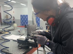 Alumna del curso Montador de Estructuras Aeronáuticas taladrando una placa de metal