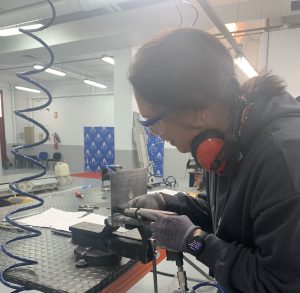 Alumna del curso Montador de Estructuras Aeronáuticas taladrando una placa de metal