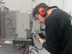Alumno del curso Montador Aeronáutico taladrando una placa de metal para su proyecto final