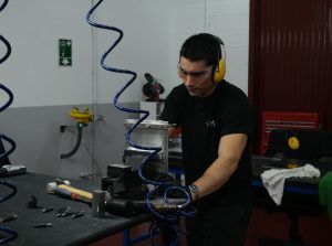 Alumno del curso Montador de Estructuras Aeronáuticas trabajando en una placa de metal